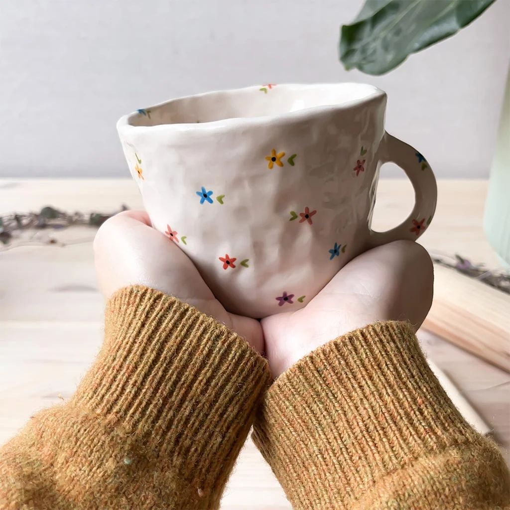 taza-pellizco-flores-multicolor-manos